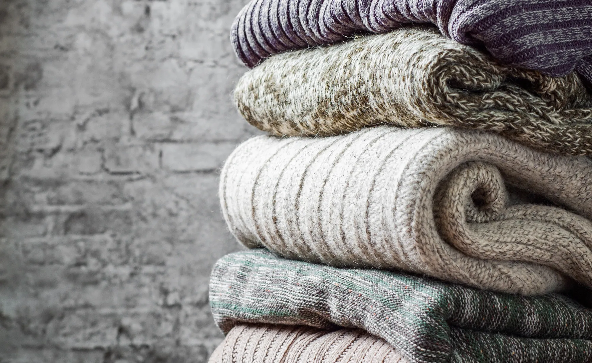 Gestapelte Strickpullover in Naturtönen